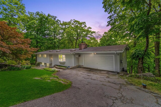 57 Hamilton Dr, Chappaqua, NY 10514 - view of front of house with an attached garage, asphalt driveway, a chimney, a yard, and a wall mounted AC