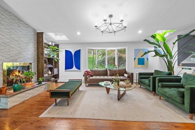 57 Hamilton Dr, Chappaqua, NY 10514 - living room with recessed lighting, wood finished floors, a chandelier, a stone fireplace, and a baseboard heating unit