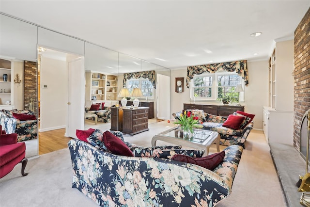 living area with ornamental molding, built in features, wood finished floors, and baseboards