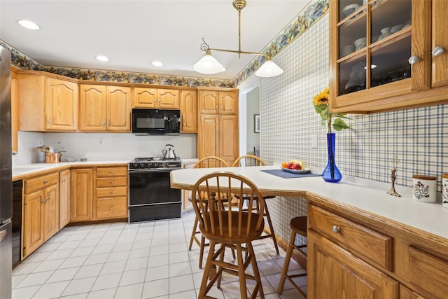 kitchen with glass insert cabinets, light countertops, black appliances, pendant lighting, and light tile patterned flooring
