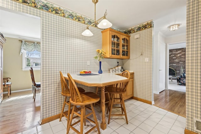 dining room with light wood-type flooring, visible vents, and baseboards