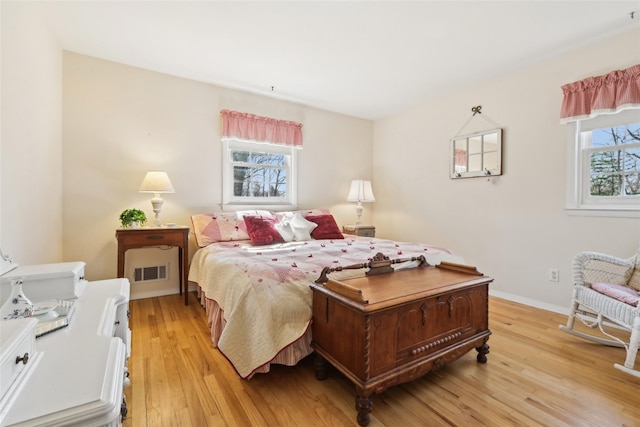 bedroom with visible vents, baseboards, and light wood-type flooring