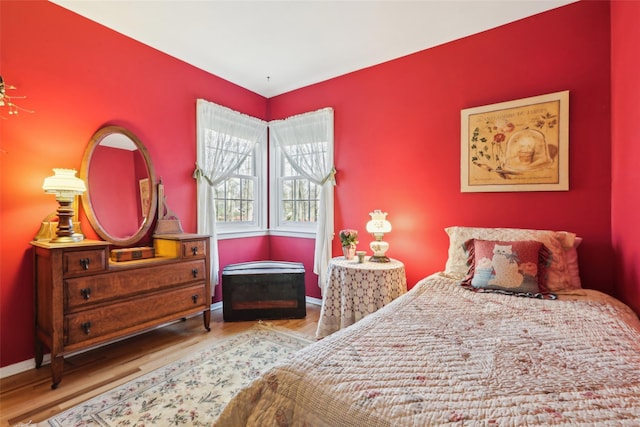 bedroom with wood finished floors and baseboards