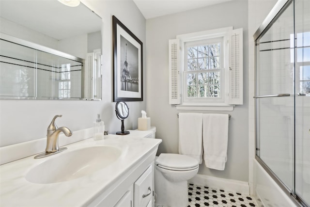 full bathroom featuring shower / bath combination with glass door, baseboards, toilet, tile patterned floors, and vanity
