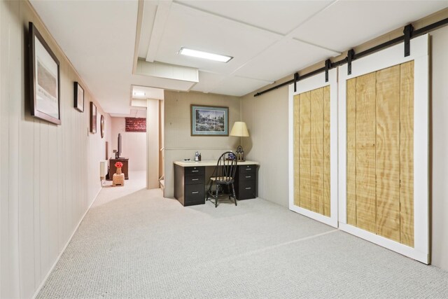 carpeted office space featuring a barn door