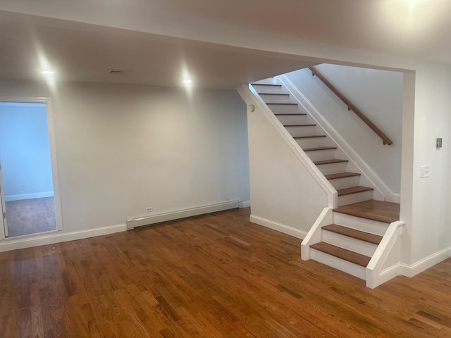 300 Prairie Dr, North Babylon, NY 11703 - below grade area featuring wood finished floors, baseboards, a baseboard heating unit, and stairway