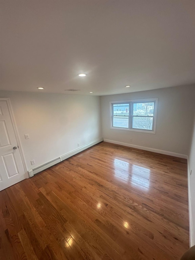 300 Prairie Dr, North Babylon, NY 11703 - spare room featuring recessed lighting, baseboards, wood finished floors, and a baseboard radiator