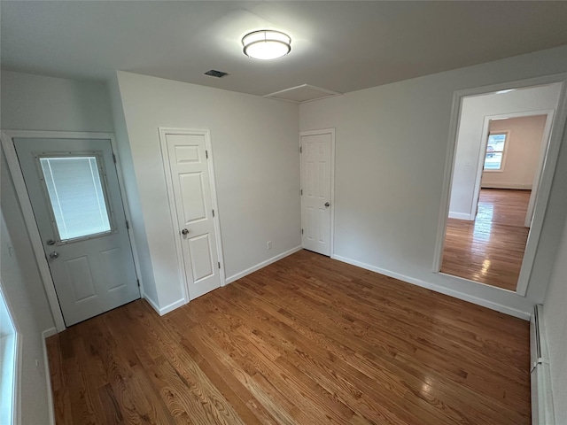 300 Prairie Dr, North Babylon, NY 11703 - unfurnished bedroom with visible vents, a baseboard radiator, baseboards, and wood finished floors