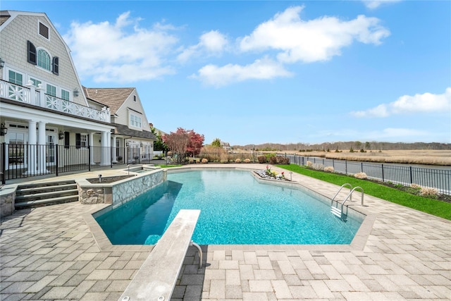 view of swimming pool featuring a diving board, a patio, fence, and a fenced in pool