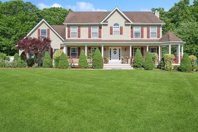 colonial inspired home featuring a front lawn, covered porch, and a chimney