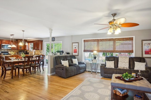living room featuring a baseboard radiator, a ceiling fan, and light wood finished floors