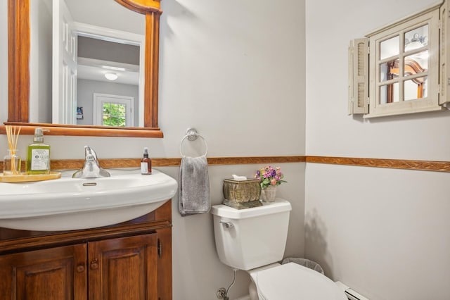 bathroom featuring baseboard heating, toilet, and vanity