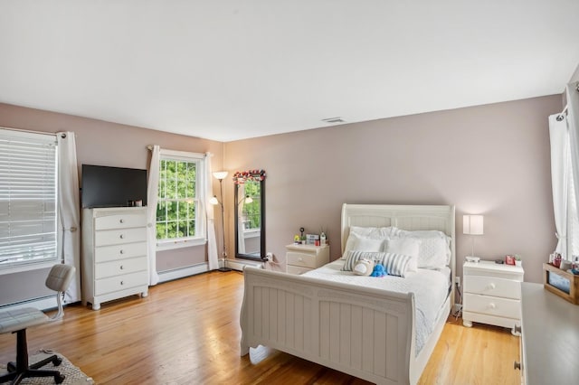 bedroom with light wood finished floors and visible vents