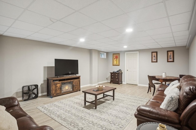 living area featuring baseboards, recessed lighting, wood finished floors, and a drop ceiling