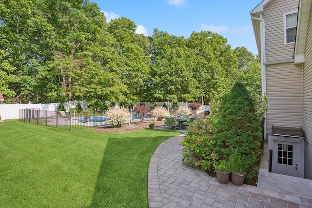view of yard with fence, a patio area, and a fenced in pool