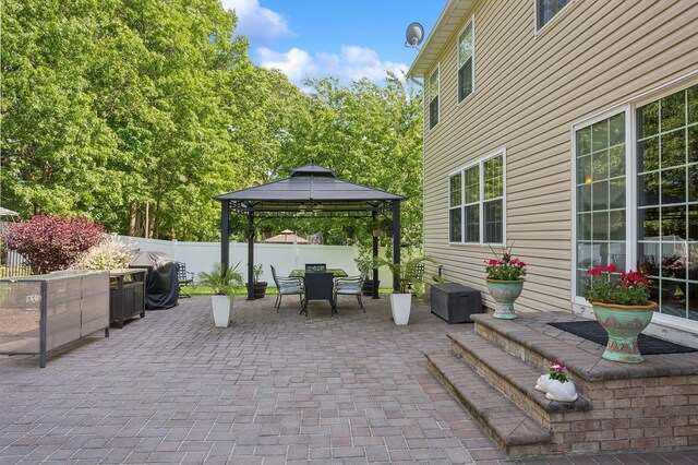 view of patio / terrace featuring a gazebo, outdoor dining space, grilling area, and a fenced backyard