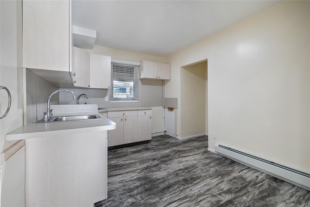 kitchen with a sink, light countertops, a baseboard radiator, dark wood-style floors, and white cabinetry