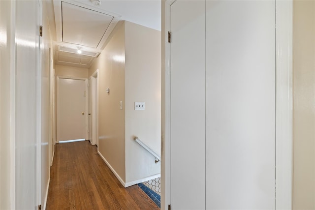 corridor featuring baseboards, attic access, wood finished floors, and an upstairs landing