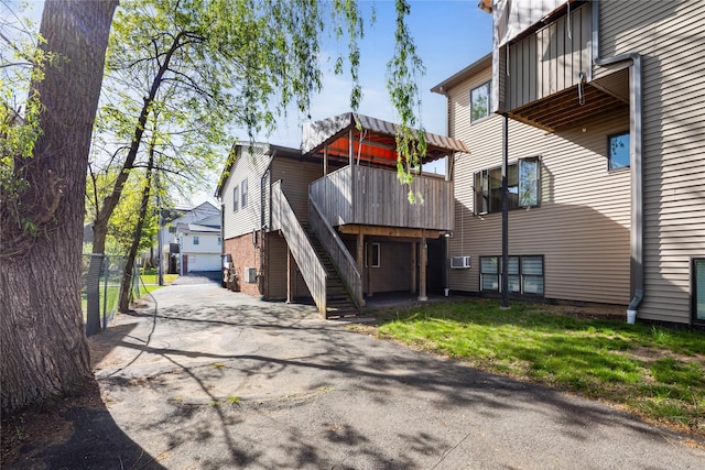 rear view of house with driveway and stairway