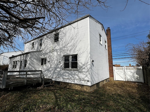 74 Jerusalem Ave, Massapequa, NY 11758 - rear view of property with a gate, fence, and a chimney