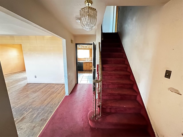 74 Jerusalem Ave, Massapequa, NY 11758 - staircase featuring a notable chandelier and wood finished floors