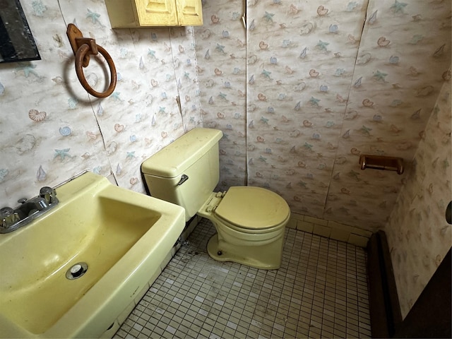 74 Jerusalem Ave, Massapequa, NY 11758 - bathroom featuring wallpapered walls, toilet, tile patterned flooring, and a sink