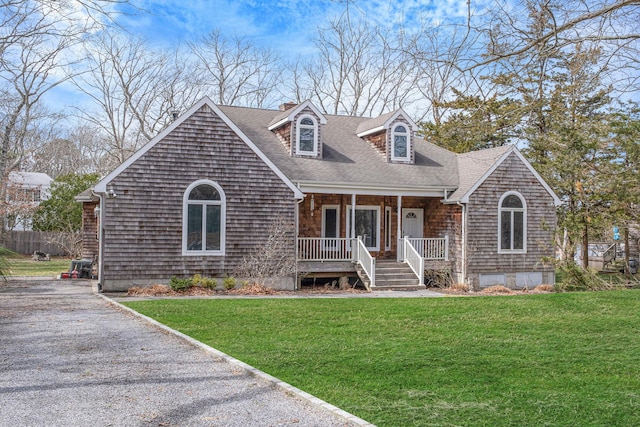 64 Turtle Cove Dr, Southampton, NY 11968 - view of front of home with gravel driveway, a front yard, a porch, a shingled roof, and a chimney