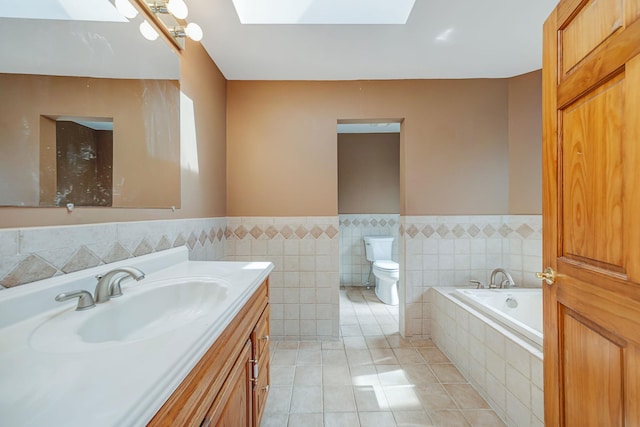 64 Turtle Cove Dr, Southampton, NY 11968 - bathroom with tile patterned floors, toilet, vanity, a garden tub, and a skylight