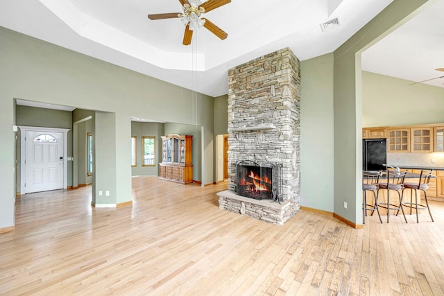 64 Turtle Cove Dr, Southampton, NY 11968 - living room featuring a tray ceiling, light wood finished floors, visible vents, a ceiling fan, and a fireplace