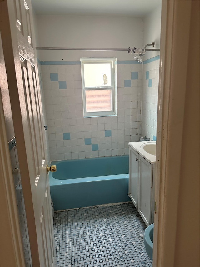 bathroom featuring tile patterned flooring, vanity, and  shower combination