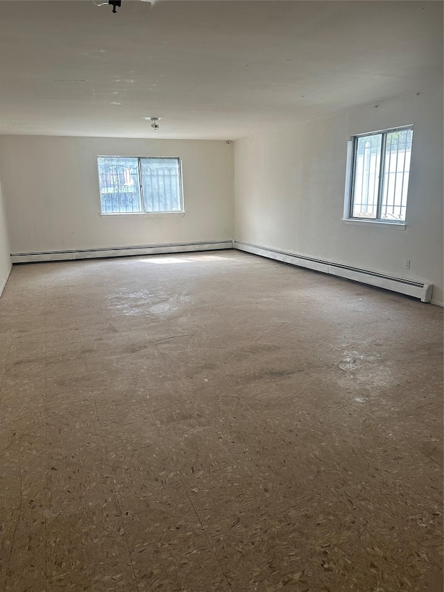 empty room with a baseboard heating unit and a wealth of natural light
