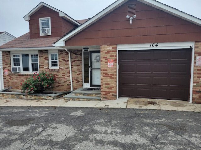 view of front of property with brick siding, driveway, a garage, and a shingled roof