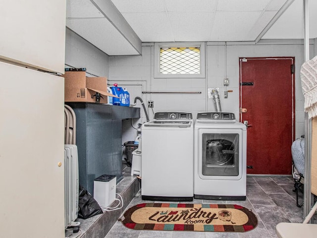 laundry area with separate washer and dryer and concrete block wall