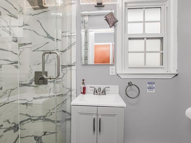 full bathroom with a marble finish shower and vanity