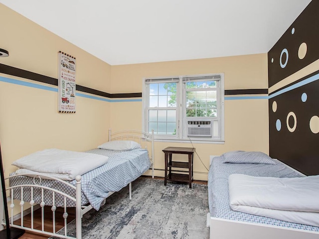 bedroom with wood finished floors, a baseboard heating unit, and baseboard heating