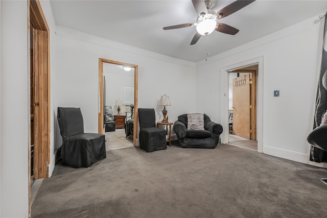 sitting room with carpet, crown molding, and ceiling fan