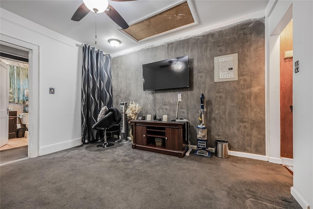 living room featuring baseboards, carpet, attic access, and a ceiling fan