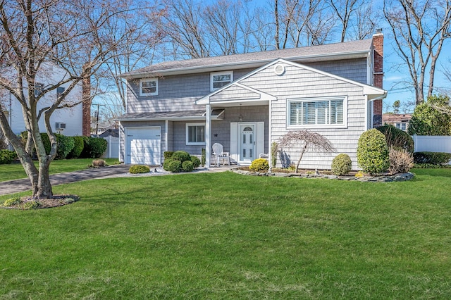 view of front of property with a chimney, a front lawn, aphalt driveway, a shingled roof, and a garage