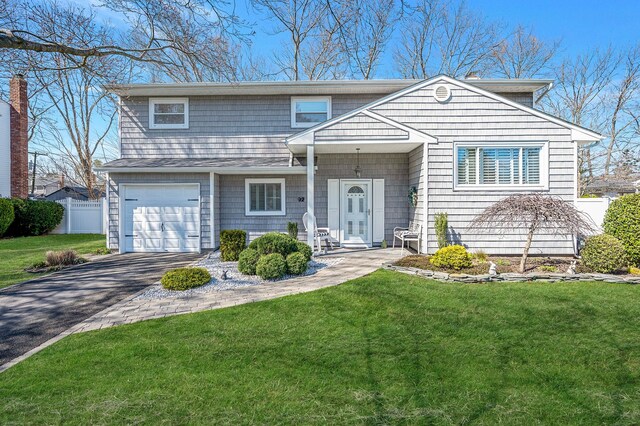 view of front of house featuring fence, driveway, a front yard, and a garage