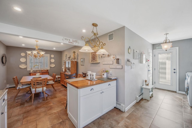 kitchen with decorative light fixtures, a baseboard radiator, and white cabinetry