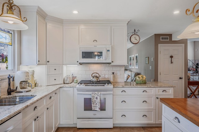 kitchen featuring a sink, white appliances, white cabinets, backsplash, and visible vents