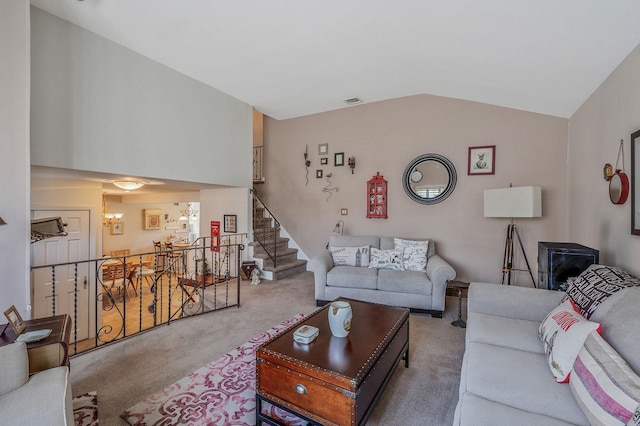 living room with lofted ceiling, carpet floors, and stairs