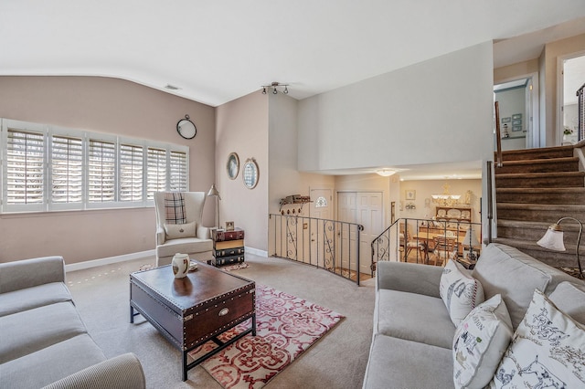 living room featuring lofted ceiling, visible vents, baseboards, carpet flooring, and a notable chandelier