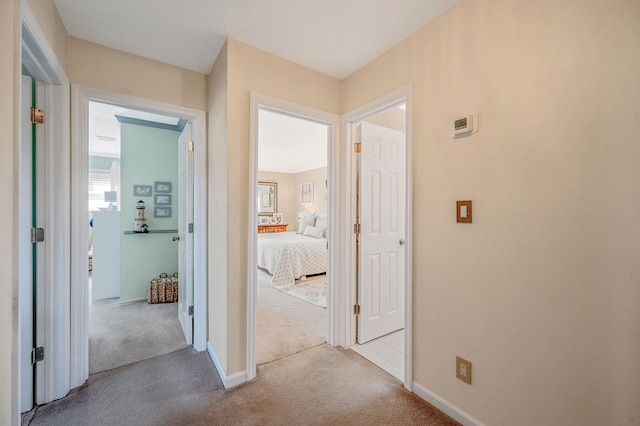 hallway featuring carpet floors and baseboards