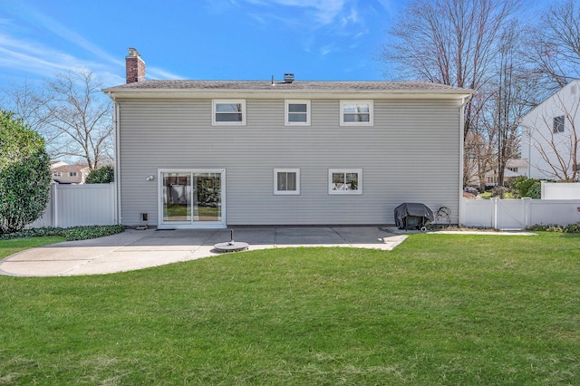 rear view of house with a lawn, a chimney, fence, and a patio area