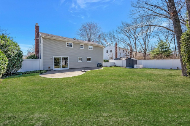 back of house featuring a storage shed, a fenced backyard, a patio, and a chimney