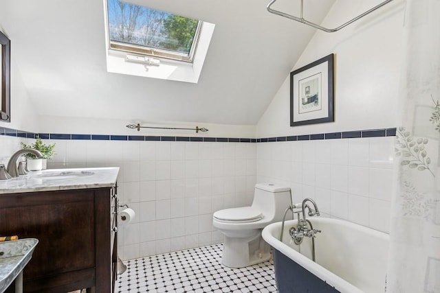 3320 Oregon Rd, Mattituck, NY 11952 - bathroom with tile walls, lofted ceiling, a freestanding tub, vanity, and toilet