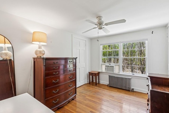 3320 Oregon Rd, Mattituck, NY 11952 - bedroom with radiator, light wood-style flooring, cooling unit, ceiling fan, and baseboards