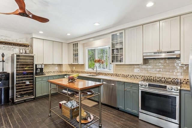 3320 Oregon Rd, Mattituck, NY 11952 - kitchen with stainless steel appliances, beverage cooler, under cabinet range hood, a sink, and decorative backsplash