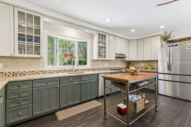 3320 Oregon Rd, Mattituck, NY 11952 - kitchen with appliances with stainless steel finishes, a sink, under cabinet range hood, tasteful backsplash, and dark wood-style flooring